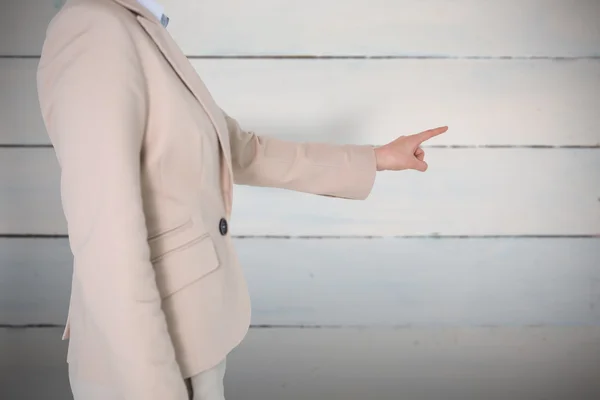 Businesswoman pointing against wooden planks — Stock Photo, Image