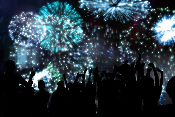 Silhouettes of cheering people against fireworks — Stock Photo, Image