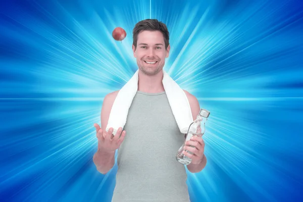 Souriant jeune homme en forme avec pomme et bouteille d'eau — Photo