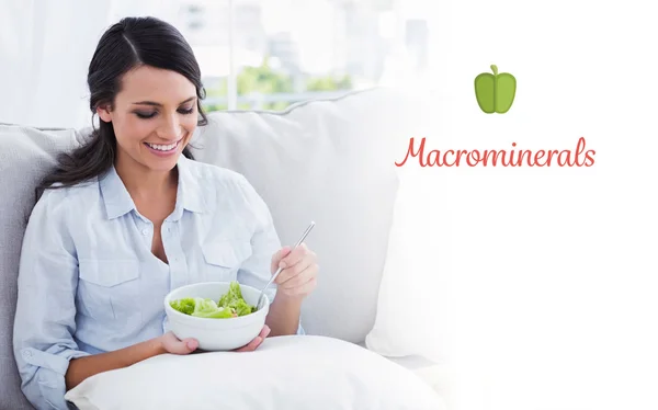 Woman relaxing on the sofa eating salad — Stock Photo, Image