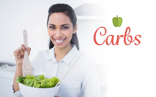 Smiling woman showing salad — Stock Photo, Image