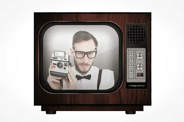 Geeky hipster holding a retro camera — Stock Photo, Image