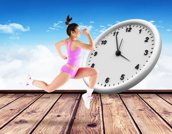 Composite image of fit brunette running and jumping — Stock Photo, Image