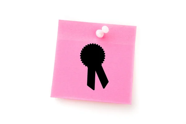 Verdienste badge tegen roze zelfklevende Opmerking — Stockfoto
