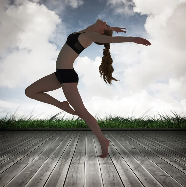 Sidovy av en sportig ung kvinna stretching — Stockfoto