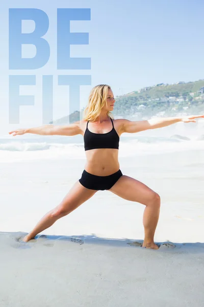 Fit blonde en posture guerrière sur la plage — Photo