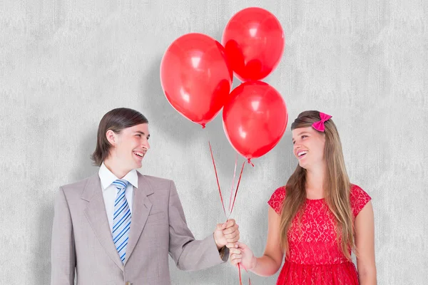 Couple geek souriant tenant des ballons rouges — Photo