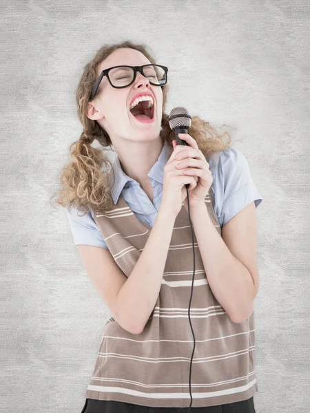 Geeky hipster woman singing into a microphone — Stock Photo, Image
