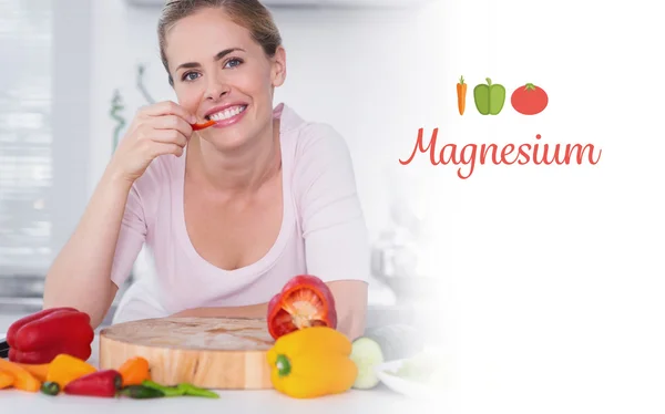 Magnesium against cheerful woman eating vegetables — Stock Photo, Image