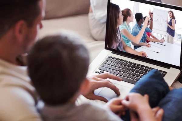 Vader en zoon met behulp van laptop in huis Stockfoto