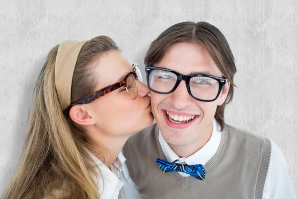 Composite image of geeky hipster kissing her boyfriend — Stock Photo, Image