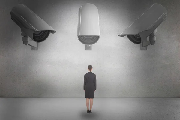 Businesswoman standing against grey room — Stock Photo, Image