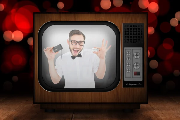 Geeky hipster holding a retro tape cassette — Stock Photo, Image