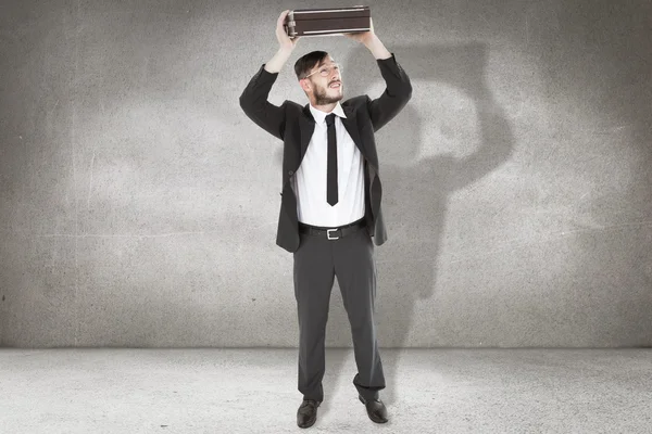 Geeky businessman holding briefcase over head — Stock Photo, Image