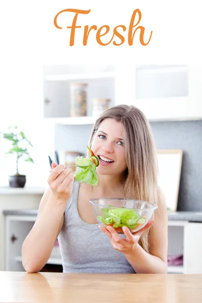 Kobieta jedząc sałatkę w kuchni — Zdjęcie stockowe