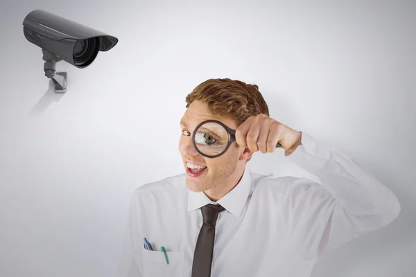 Businessman looking through magnifying glass — Stock Photo, Image