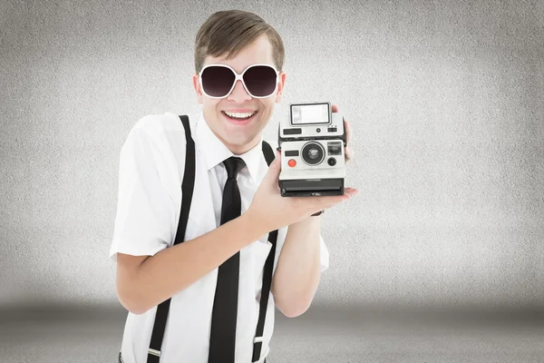 Geeky hipster segurando uma câmera retro — Fotografia de Stock