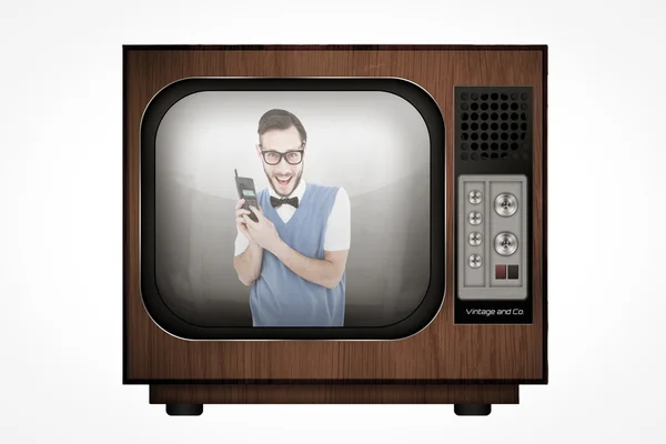 Geeky hipster holding a retro cellphone — Stock Photo, Image