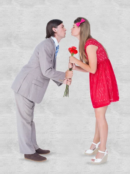 Composite image of cute geeky couple kissing — Stock Photo, Image