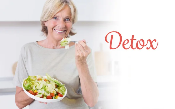 Desintoxicación contra la mujer sonriente comiendo ensalada —  Fotos de Stock