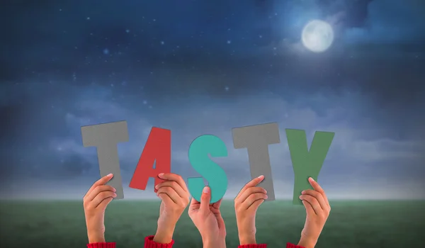 Composite image of hands holding up tasty — Stock Photo, Image