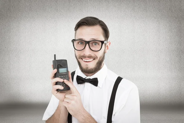 Geeky hipster segurando um celular retro — Fotografia de Stock