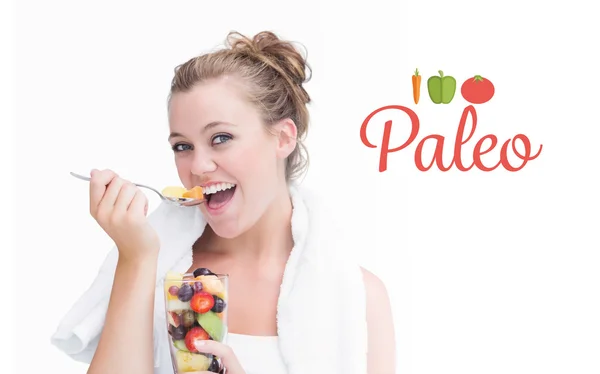 Paleo against woman eating fruit and smiling — Stock Photo, Image