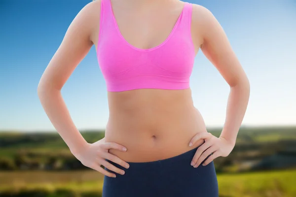 Toned woman with hands on hips on beach — Stock Photo, Image