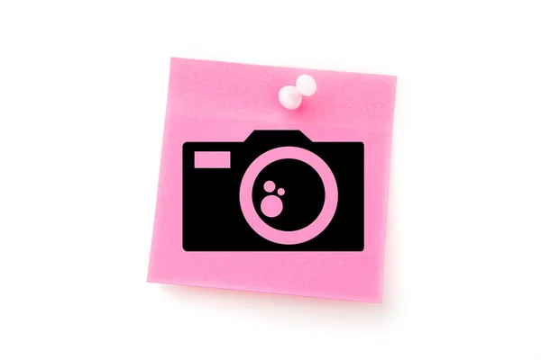 Câmera contra nota adesiva rosa — Fotografia de Stock
