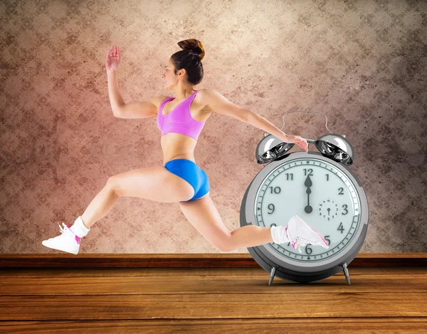 Composite image of fit brunette running and jumping — Stock Photo, Image