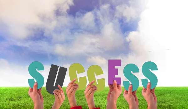 Composite image of hands holding up success — Stock Photo, Image