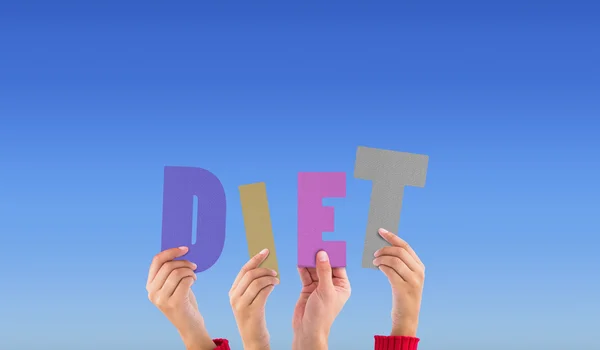 Composite image of hands holding up diet — Stock Photo, Image