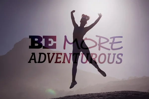 Sporty blonde on the beach on a rock jumping — Stock Photo, Image