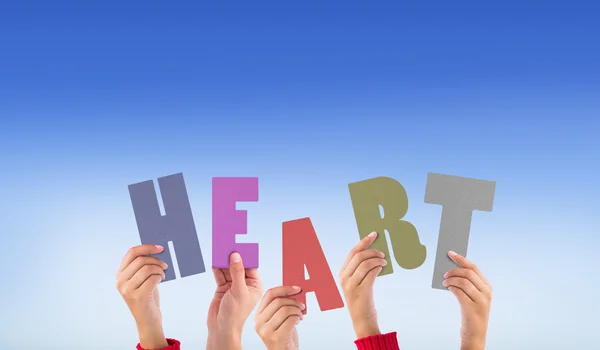 Composite image of hands holding up heart — Stock Photo, Image