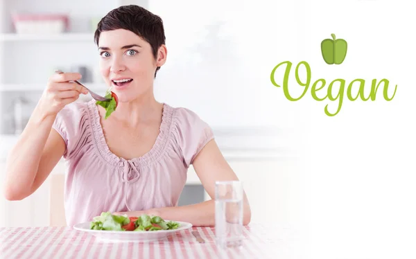 Vegan against charming woman eating salad — Stock Photo, Image