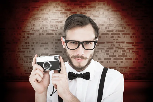 Geeky hipster segurando uma câmera retro — Fotografia de Stock