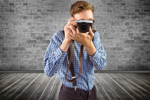 Geeky hipster holding a retro camera — Stock Photo, Image