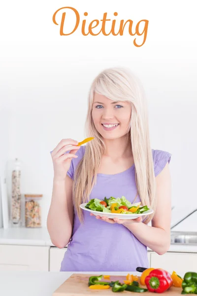 Atractiva hembra sonriente comiendo su ensalada — Foto de Stock
