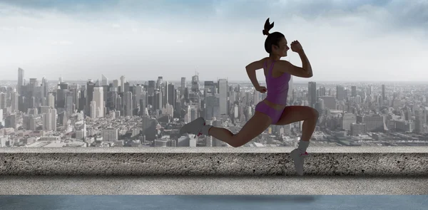 Komposit billede af fit brunette løb og hoppe - Stock-foto