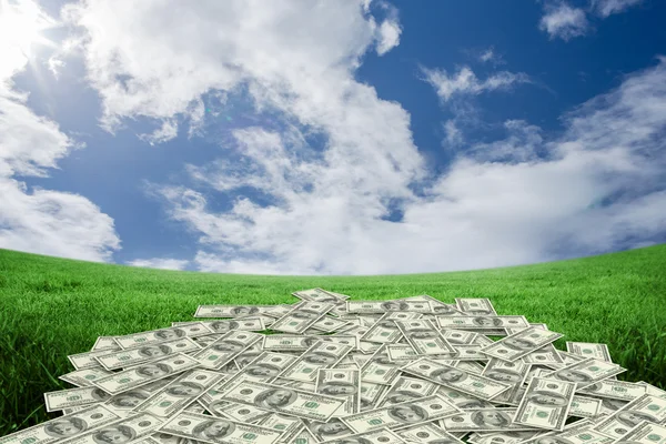 Pile of dollars against field under sky — Stock Photo, Image