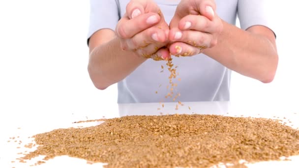 Mulher derramando grãos no fundo branco — Vídeo de Stock