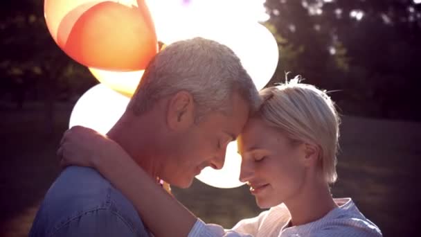 Pareja romántica con globos en parque — Vídeos de Stock