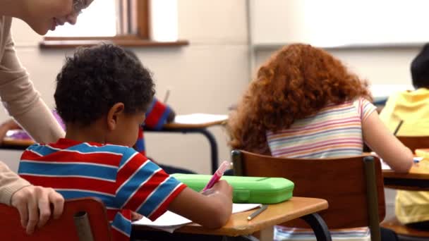 Lehrer hilft einem kleinen Jungen im Unterricht — Stockvideo