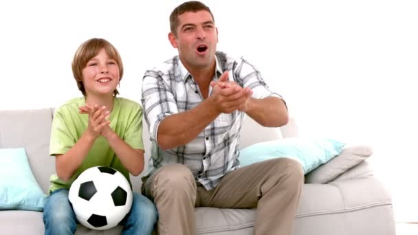 Pai e filho com futebol assistindo tv — Vídeo de Stock