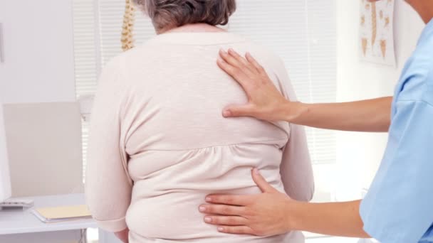 Fisioterapeuta examinando pacientes ancianos espalda — Vídeos de Stock