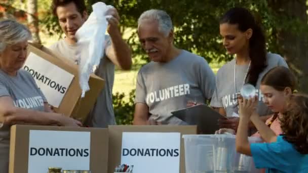 Equipo de voluntarios felices recogiendo donaciones — Vídeo de stock