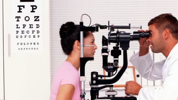 Optician examining a patients eyes — Stock Video