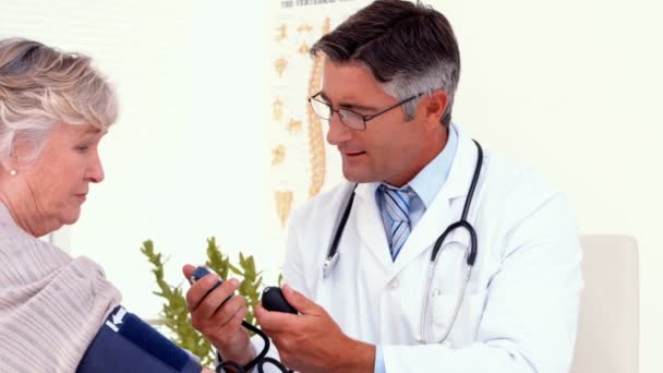 Doctor taking blood pressure of his patient — Stock Video