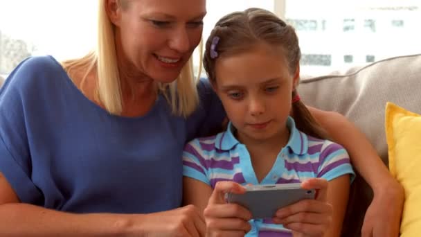 Filha jogando jogo no telefone com a mãe — Vídeo de Stock