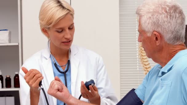 Doctor taking blood pressure of elderly patient — Stock Video